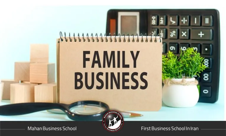 دفترچه با عنوان کسب‌وکار خانوادگی در کنار ماشین حساب و گیاه تزئینی روی میز